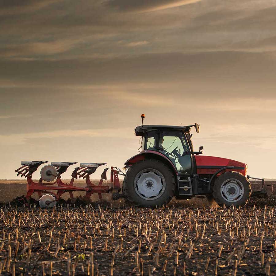 A tractor with a plough on a field